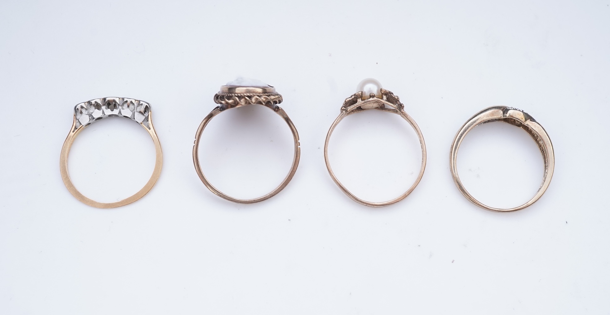 A collection of four rings and a pendant